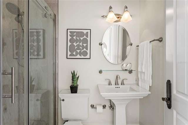 bathroom featuring toilet and a stall shower