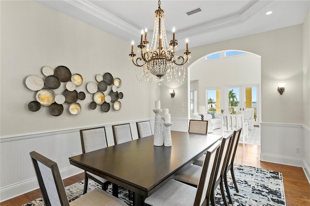 dining room with visible vents, a chandelier, wainscoting, wood finished floors, and arched walkways