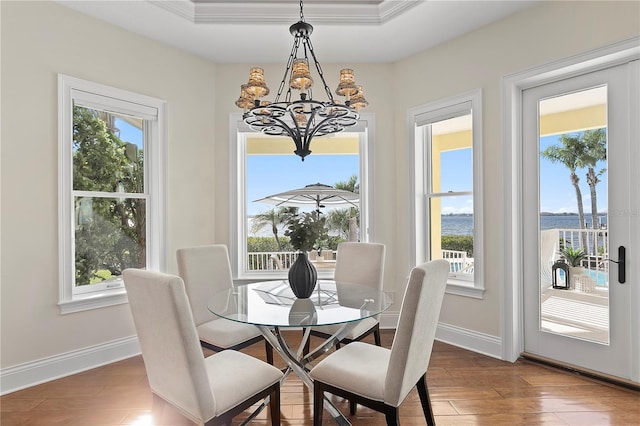 dining space featuring baseboards, an inviting chandelier, and wood finished floors