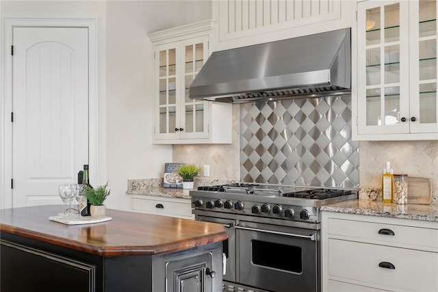 kitchen with tasteful backsplash, a center island, double oven range, wall chimney exhaust hood, and wood counters