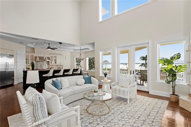 living area featuring dark wood-style floors, baseboards, a wealth of natural light, and ceiling fan