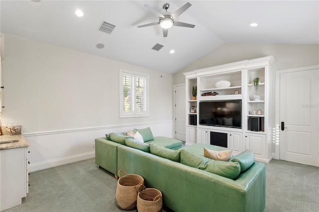 living area featuring a wainscoted wall, ceiling fan, visible vents, and light carpet