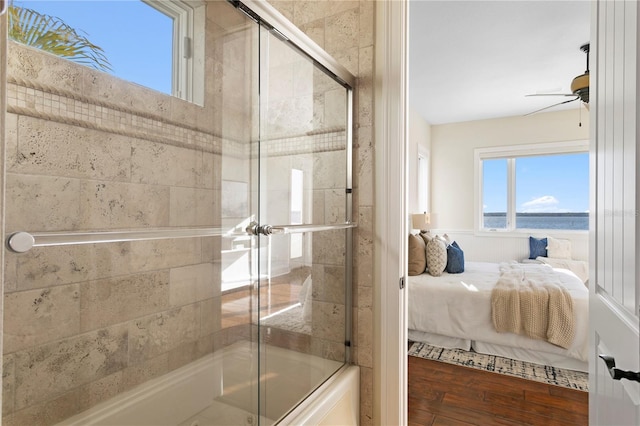 ensuite bathroom featuring shower / bath combination with glass door, ensuite bathroom, ceiling fan, and wood finished floors