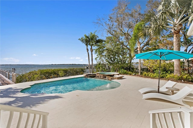 view of pool with a patio, a water view, and a pool with connected hot tub