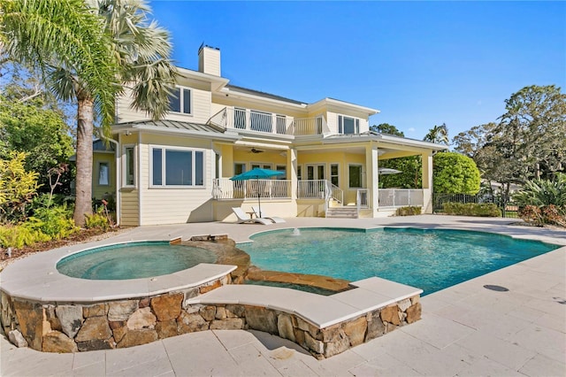 view of swimming pool featuring a patio, fence, a ceiling fan, a fenced in pool, and an in ground hot tub