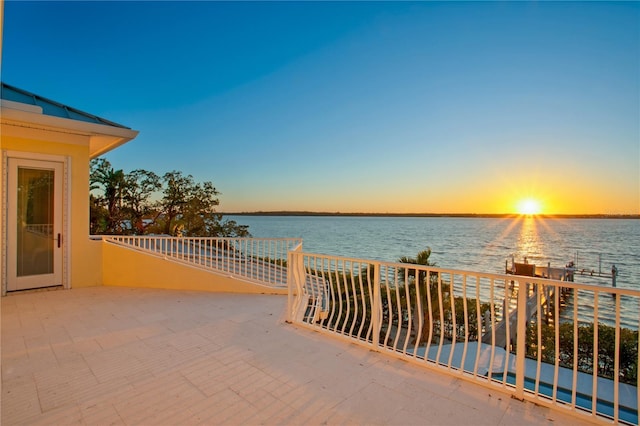 view of patio with a balcony and a water view