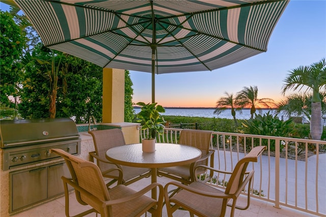 view of patio / terrace with outdoor dining space, area for grilling, a water view, and a grill