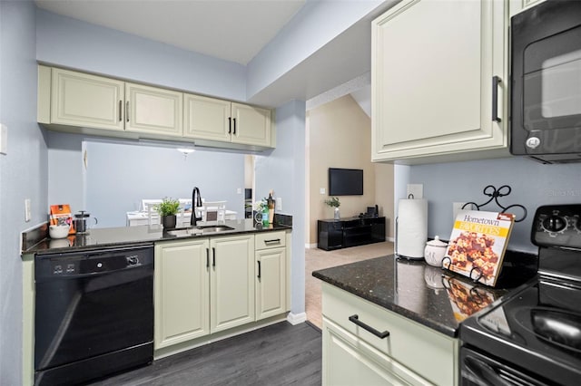 kitchen featuring dark hardwood / wood-style floors, sink, dark stone countertops, black appliances, and cream cabinetry