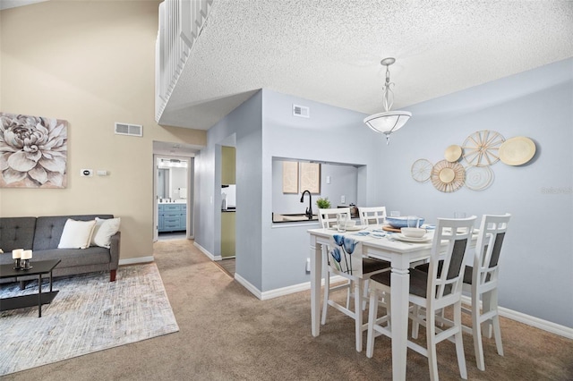 carpeted dining area with a textured ceiling