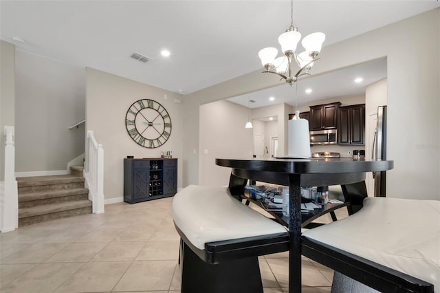 tiled dining space with a chandelier