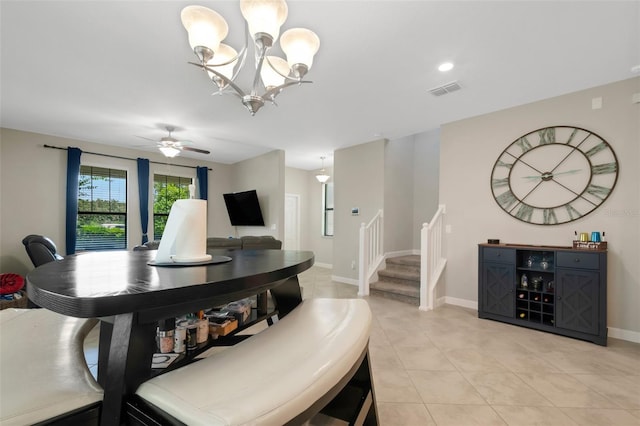 dining area featuring ceiling fan with notable chandelier and light tile patterned flooring