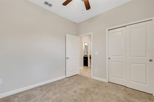 unfurnished bedroom with light carpet, ceiling fan, and a closet