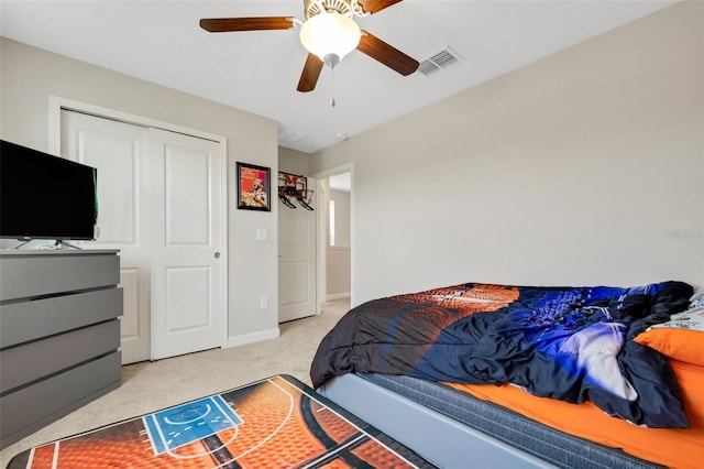 carpeted bedroom featuring ceiling fan and a closet