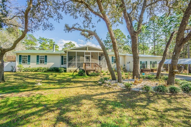 view of front of home with a sunroom and a front lawn