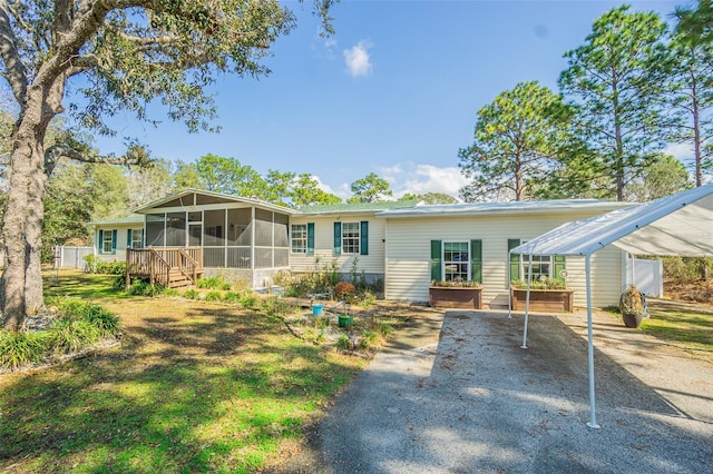 back of property with a carport and a sunroom