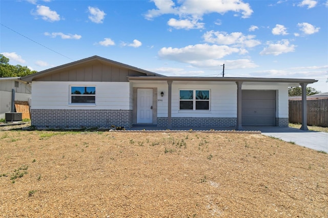 single story home with central AC unit, a garage, a front lawn, and a carport