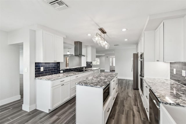 kitchen featuring appliances with stainless steel finishes, wood finish floors, white cabinetry, and island range hood