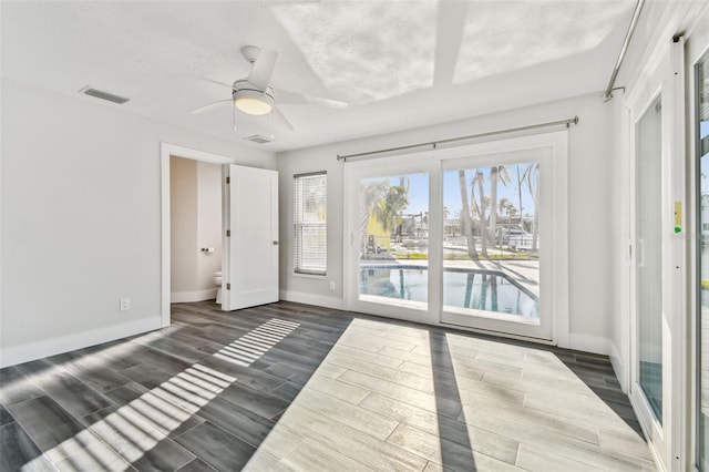 unfurnished bedroom with baseboards, access to outside, visible vents, and wood tiled floor