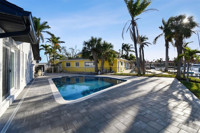 outdoor pool with a patio area and fence