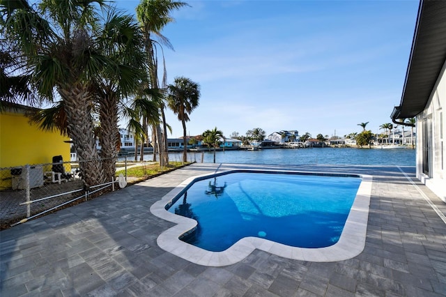 pool featuring a water view and a patio area