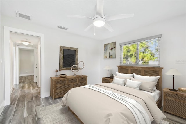 bedroom featuring light wood-style flooring, visible vents, and a ceiling fan