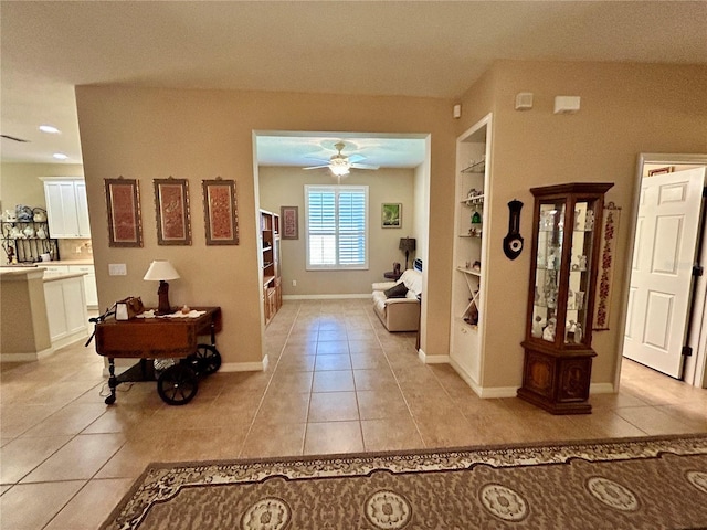 hall with light tile patterned floors, baseboards, and built in shelves