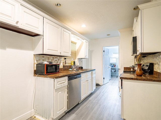 kitchen featuring dishwasher, light wood-type flooring, backsplash, sink, and white cabinetry