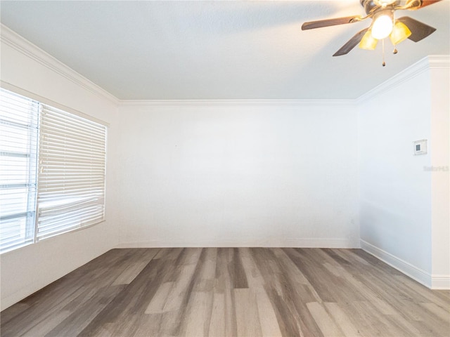 spare room with a healthy amount of sunlight, hardwood / wood-style flooring, and crown molding