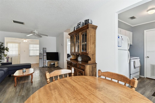 dining area with ceiling fan, dark wood-type flooring, and a textured ceiling