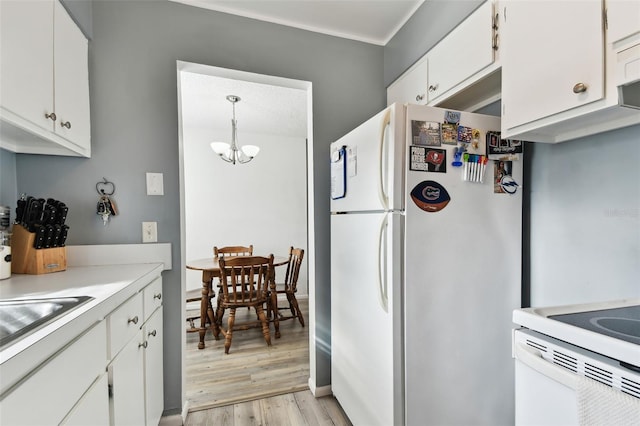 kitchen with light hardwood / wood-style flooring, white cabinetry, hanging light fixtures, an inviting chandelier, and white refrigerator