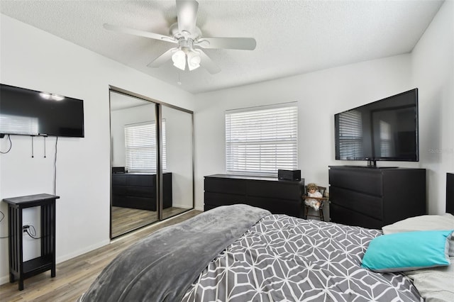 bedroom with ceiling fan, a closet, a textured ceiling, and light wood-type flooring