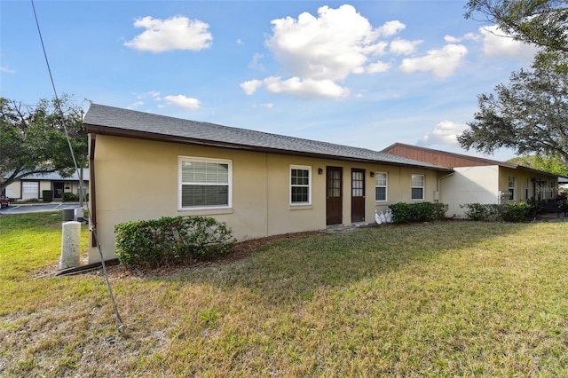 rear view of property featuring a lawn