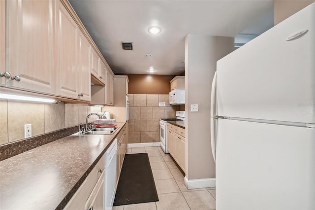 kitchen featuring tasteful backsplash, sink, tile walls, light tile patterned floors, and white appliances