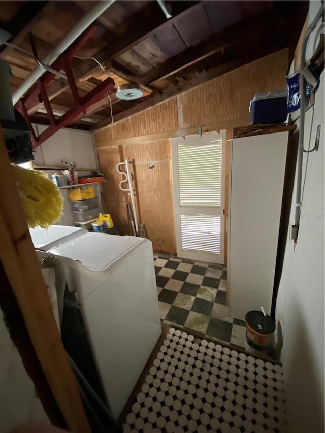 clothes washing area with washer / dryer and wooden walls