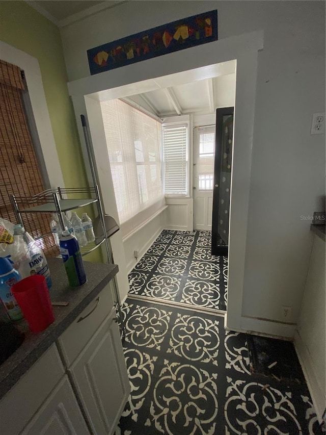 interior space with ornamental molding and tile patterned floors