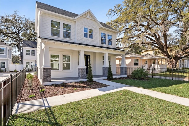 craftsman inspired home featuring a porch, a fenced front yard, and a front lawn