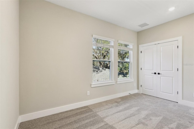 unfurnished bedroom with baseboards, a closet, visible vents, and carpet flooring