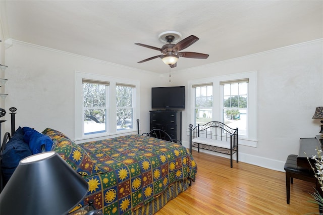 bedroom with hardwood / wood-style floors, crown molding, and ceiling fan