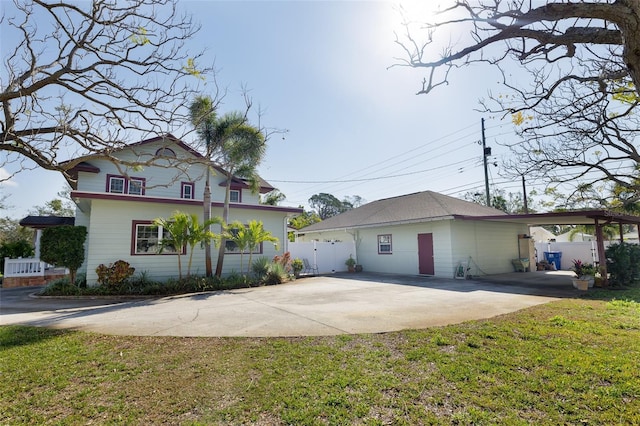 view of side of home featuring a lawn and a carport