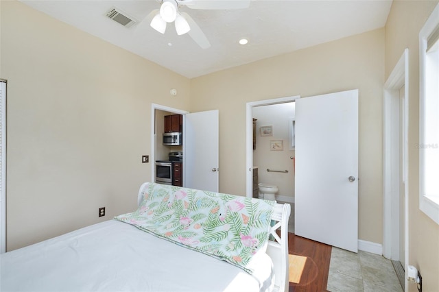 bedroom featuring light tile patterned floors, ceiling fan, and ensuite bathroom