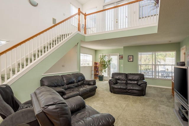 carpeted living room featuring a high ceiling