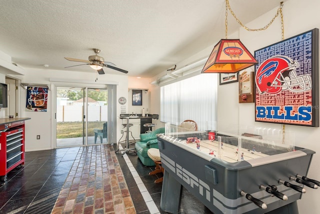 game room with wine cooler, ceiling fan, and a textured ceiling