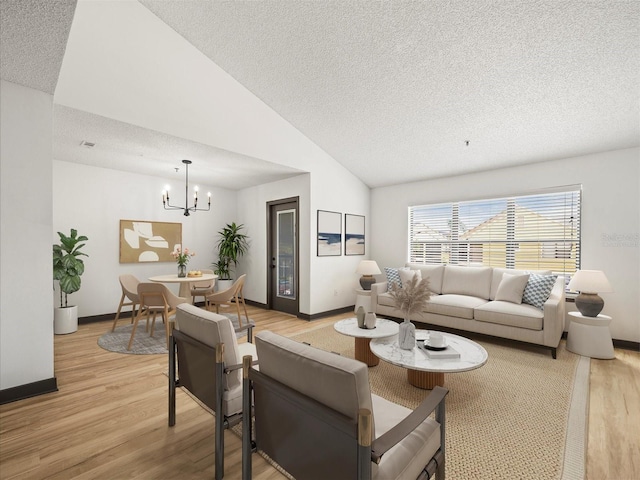 living room with lofted ceiling, a textured ceiling, and light hardwood / wood-style floors