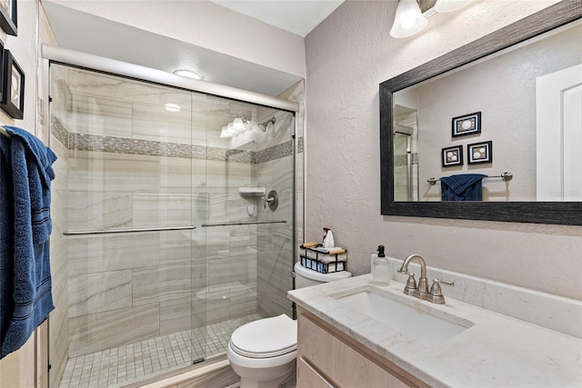 bathroom featuring vanity, toilet, and walk in shower