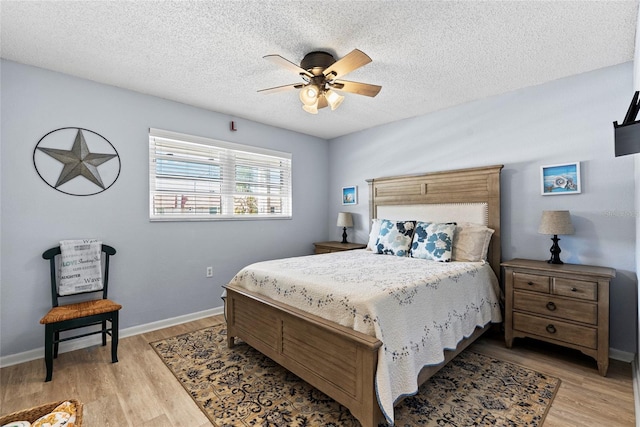 bedroom featuring ceiling fan, a textured ceiling, and light wood-type flooring