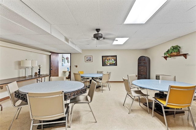 dining area with a drop ceiling and ceiling fan