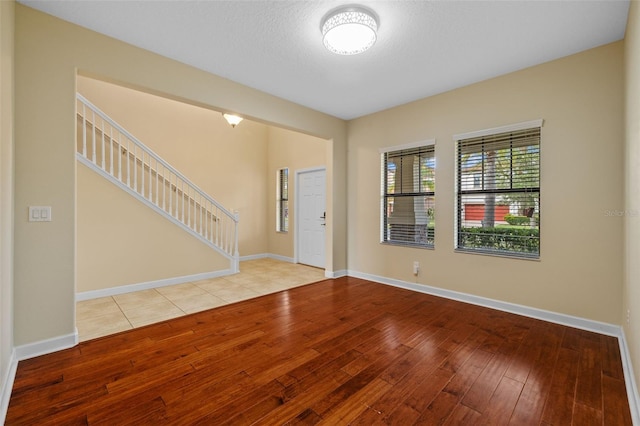 entryway with a textured ceiling and light wood-type flooring