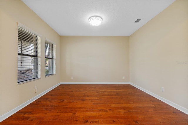 unfurnished room featuring hardwood / wood-style floors and a textured ceiling