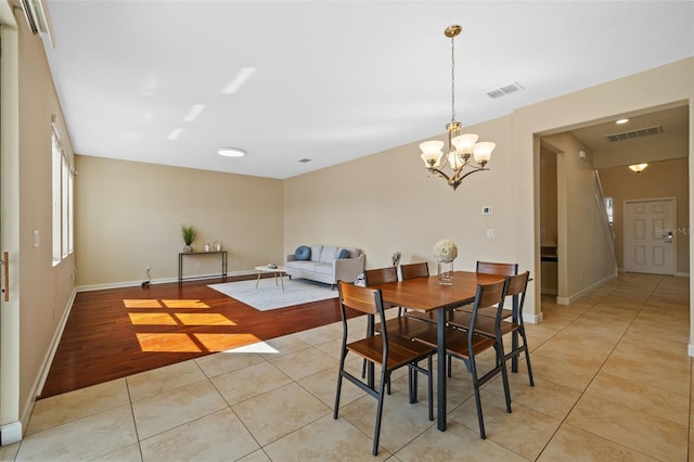 tiled dining room featuring a chandelier