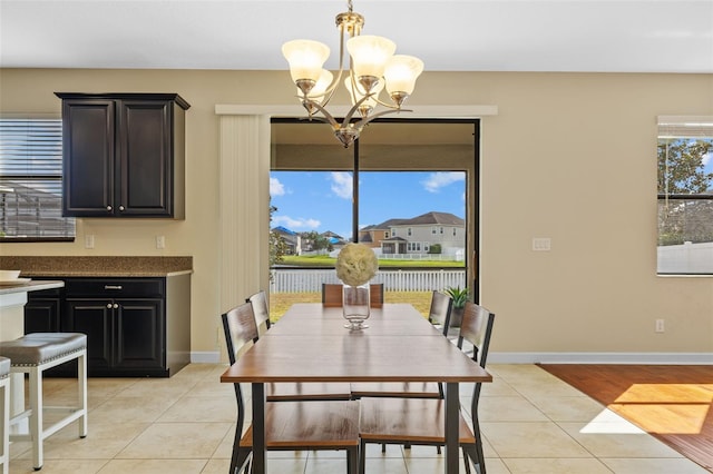 dining area with light tile patterned floors and a chandelier